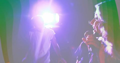 Singer Holding Microphone on Club Stage with Vibrant Lighting