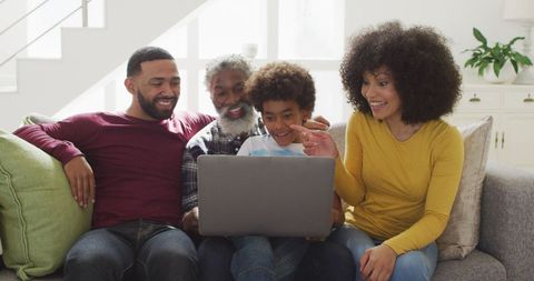 Joyful Multi-Generational Family Using Laptop in Cozy Living Room