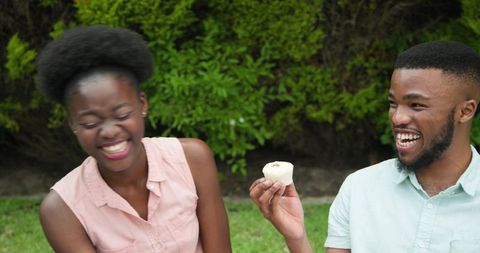 Young Couple Enjoying Outdoor Laugh with Refreshments
