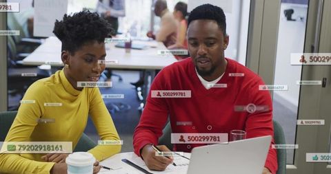 Collaborating over laptop with digital data overlays in modern open office workspace