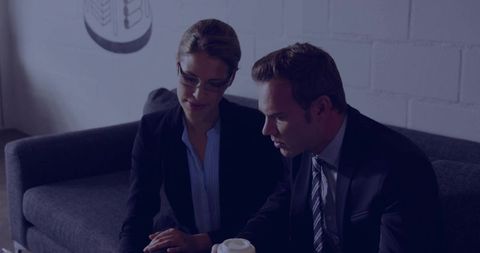 Business Professionals Reviewing Report on Office Sofa