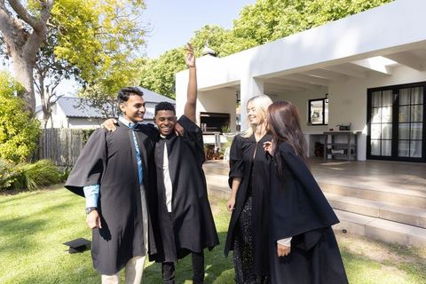 Diverse Friends Celebrating Graduation Outdoors in Black Gowns