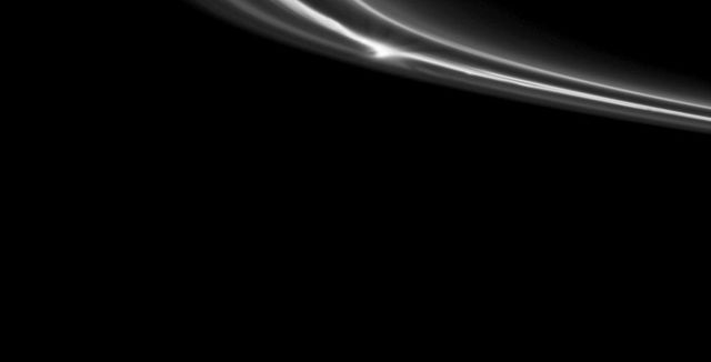 A bright clump of material within Saturn tenuous F ring stands out near the center top of this NASA Cassini spacecraft image.