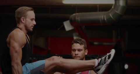 Two Men Exercising with Assistance at an Urban Gym