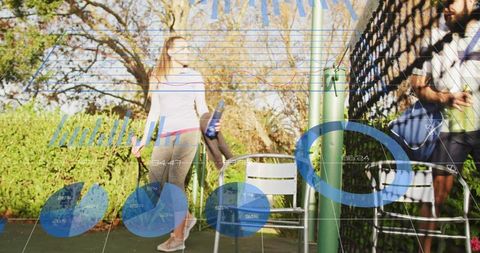 Fit woman walking from tennis court holding reusable bottle and towel with partner