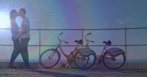 Romantic Couple Kissing by Waterfront at Sunset with Bicycles