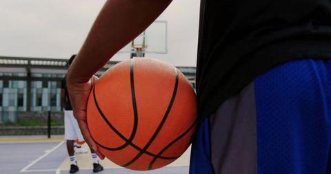 Basketball Player on Sunny Outdoor Court Holding Ball