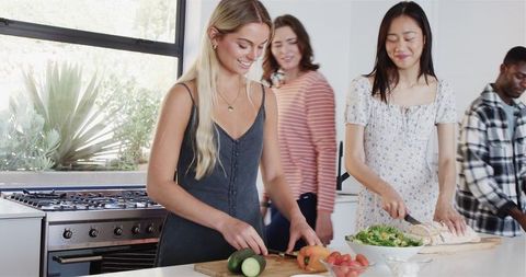 Joyful Friends Preparing Food Together at House-Warming Party