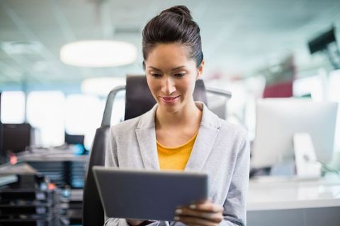 Chinese Woman Using Tablet in Modern Office Environment