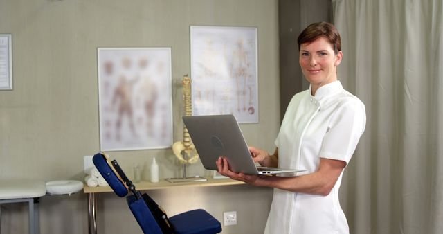 Female physiotherapist using laptop in clinic 4k