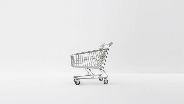 Chrome shopping cart sitting on white high-key minimal background for retail concept