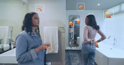 Women exploring smart bathroom augmented reality interface while preparing at mirror