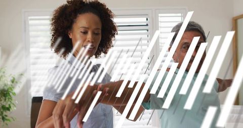 Caregiver guiding senior through arm mobility exercise in bright home with shutters