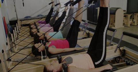 Diverse Group of Women Practicing Pilates on Reformers