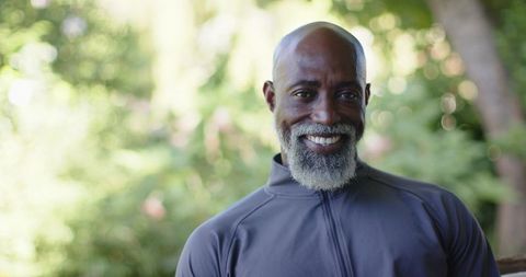 Mature african american man smiling outdoors wearing dark gray zip-up athletic jacket