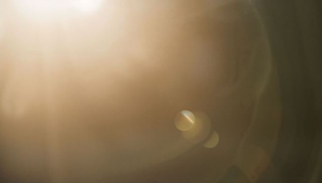 Golden lens flare with soft glow abstract background