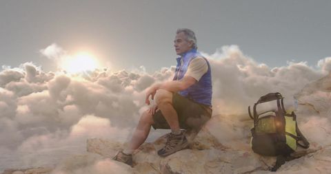 Adventurous Man Enjoys Sunset on Mountain Peak with Backpack
