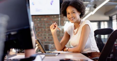 Confident businesswoman writing planning in modern office