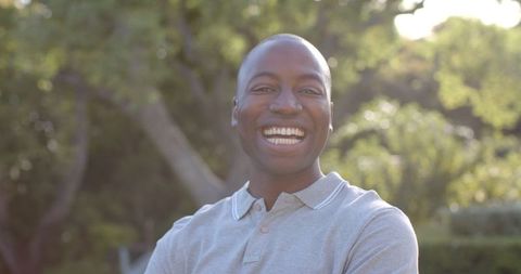 Joyful man smiling in sunlit park