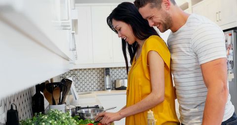 Couple Enjoying Cooking Together at Home in Bright Kitchen