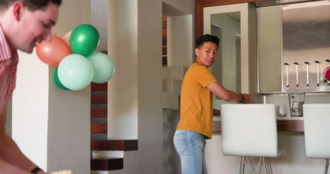 Joyful Gay Couple Dancing at Home Celebrating Festive Occasion