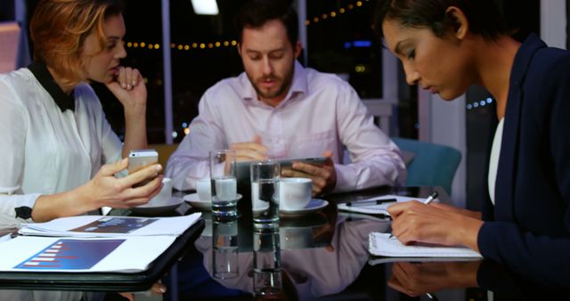 Business Team Meeting at Night with Documents and Tablets - Download Free Stock Images Pikwizard.com