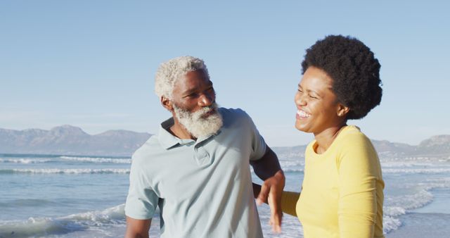 Elderly couple enjoying each other's company on a scenic beach. Perfect for promoting retirement communities, vacation packages, health and wellness campaigns, and seniors' recreational activities.