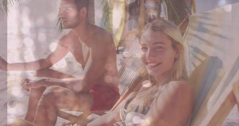 Couple Relaxing on Tropical Beach Under Palm Trees