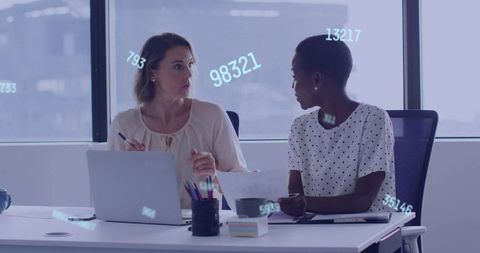 Colleagues discussing data on laptop with digital number overlays in modern office