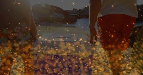 Friends carrying cooler on sandy sunset beach adventure