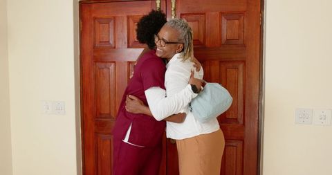 Doctor and Senior Patient Sharing Warm Embrace in Hospital Foyer