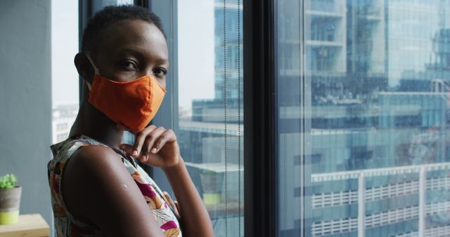 Confident African Woman Wearing Mask by Window in Office Building - Download Free Stock Images Pikwizard.com