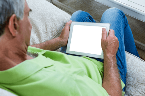 senior man relaxing on sofa using transparent tablet - Download Free Stock Videos Pikwizard.com