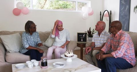 Elderly friends celebrating a cancer survivor at cozy gathering