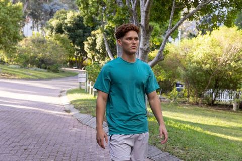 Man Leisurely Strolling Through Green Suburban Path