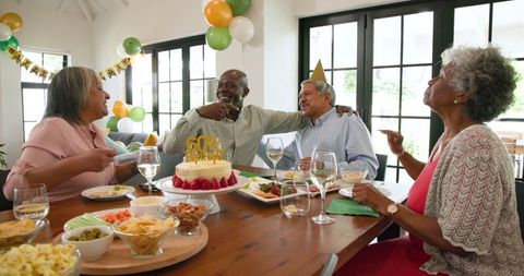 Senior Friends Celebrating 60th Birthday Party in Living Room