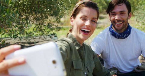 Smiling Couple Taking Selfie in Sunlit Outdoor Adventure
