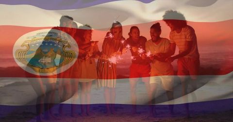 Friends Celebrating with Sparklers at Beach with Flag Overlay