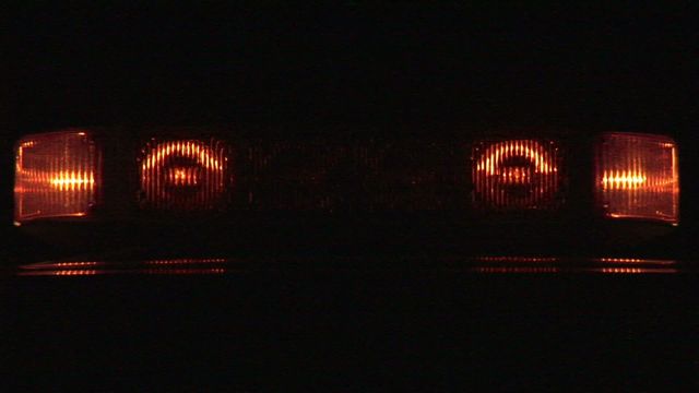 Flashing red warning lights on an emergency vehicle shown vividly in the dark. The vibrant glow suggests urgency and alertness. Ideal for use in articles or presentations related to emergency services, vehicle safety, criminal justice contexts, or public awareness campaigns about the importance of emergency signals.