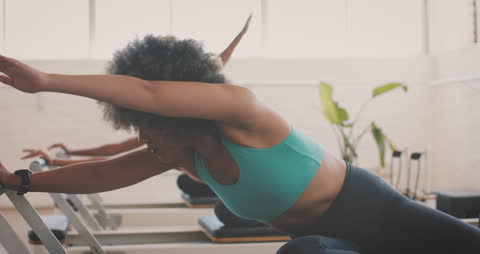 Energetic Woman Stretching on Pilates Reformer in Studio