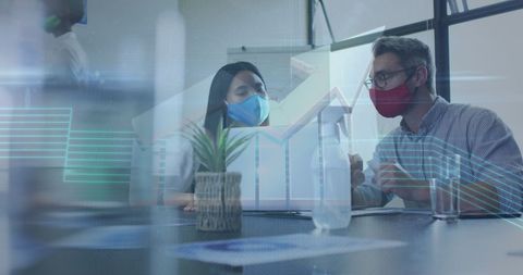 Colleagues in Face Masks Analyzing Data with Digital Overlay