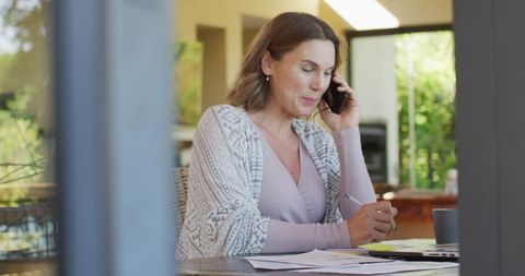 Pregnant Woman Working from Home Using Smartphone and Laptop