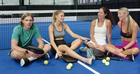 Group of Friends Chatting on Padel Court During Break