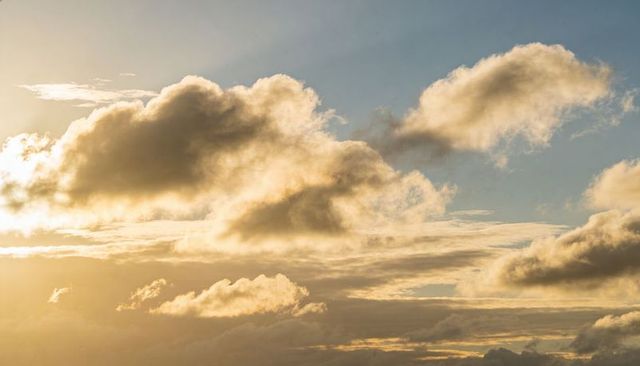 Golden Backlit Cloudscape Over Horizon Creating Dramatic Sky Gradient at Sunrise Sunset