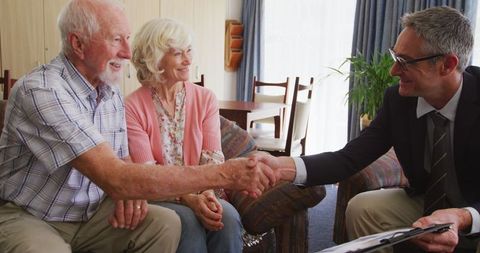 Happy senior couple making decision with advisor at home