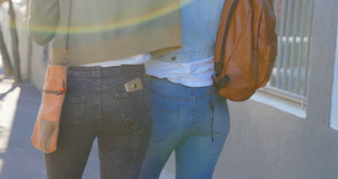 Siblings Walking Together on City Sidewalk