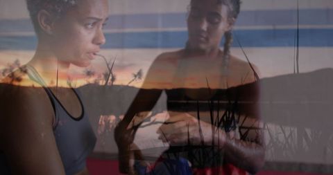 Athletes adjusting fitness tracker in gym overlaid with tropical sunset
