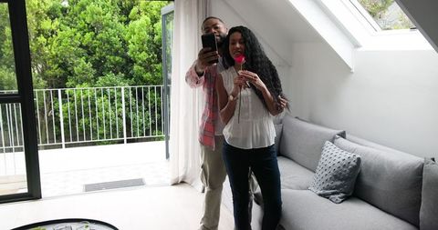 Couple celebrating engagement with selfie at home