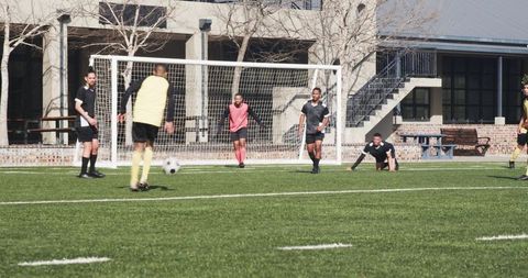 Soccer Players Engaged in Practice on Sunny Field