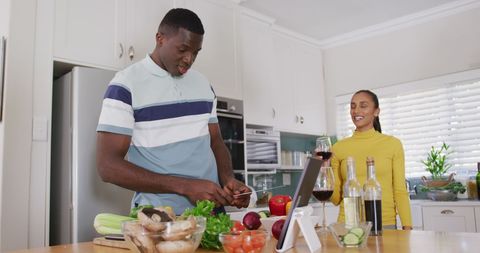 Happy Couple Cooking Together in Modern Kitchen with Wine